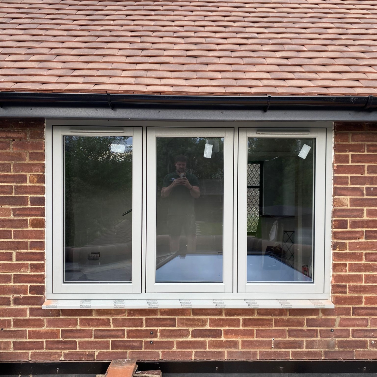 Residence 7 window with white internal frame and Painswick exterior, installed in a brick façade in Guildford